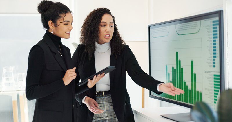 Business women, teamwork and computer screen for data analysis, digital marketing research and social media report. Professional analyst, manager and clients with graphs, statistics and tablet review.