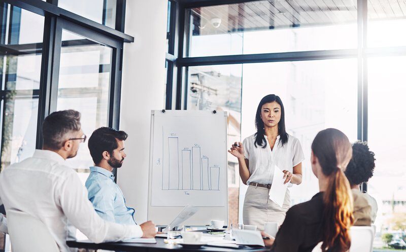 Meeting, male leader and boardroom in office with colleagues, graphs and presentation for business planning. Communication, management and strategy discussion, financial analysis and accounting firm.